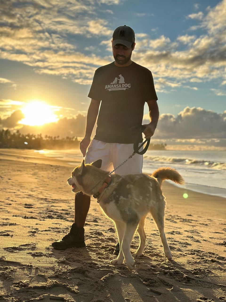 Eduardo com husky na praia ao pôr do sol